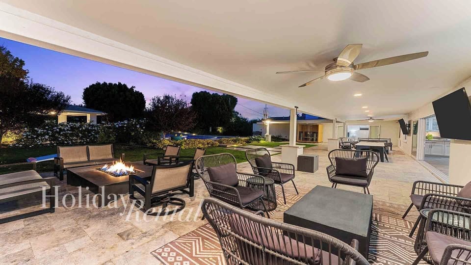 As dusk falls, fire pits, TVs & modern seating make this patio shine.
