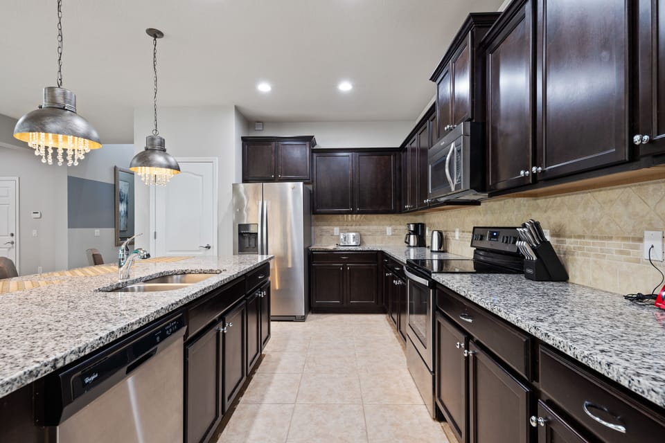Elegant kitchen area with oven, microwave, refrigerator and dish washer