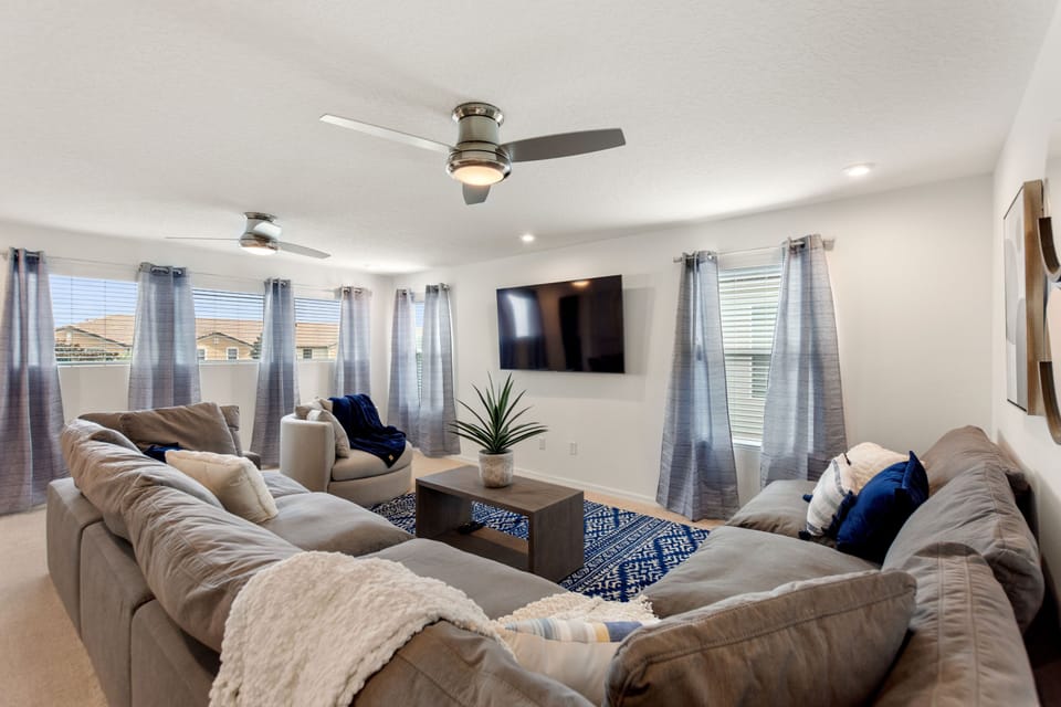 Comfortable open-plan living area with ample seating and flat-screen TV