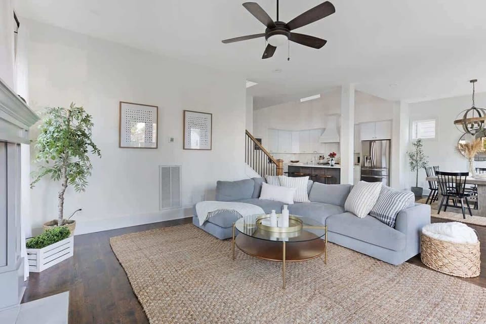 The light and bright living room features a large sectional, open to the kitchen and dining room, creating a spacious and inviting area for entertaining.