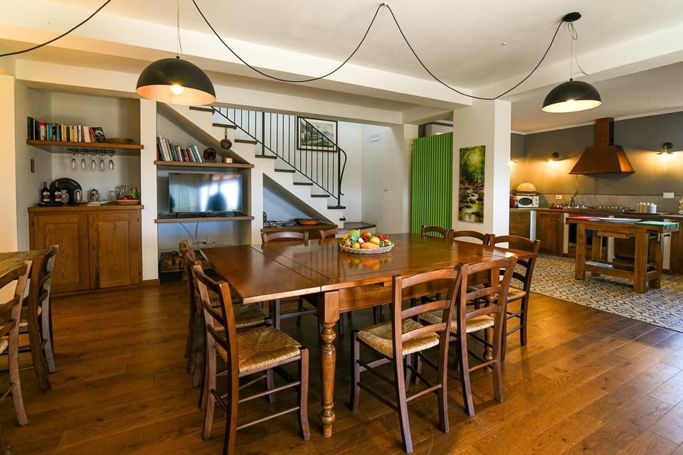 Open-plan living room with sofa, dining area, kitchen, A/C, WiFi internet, and satellite TV