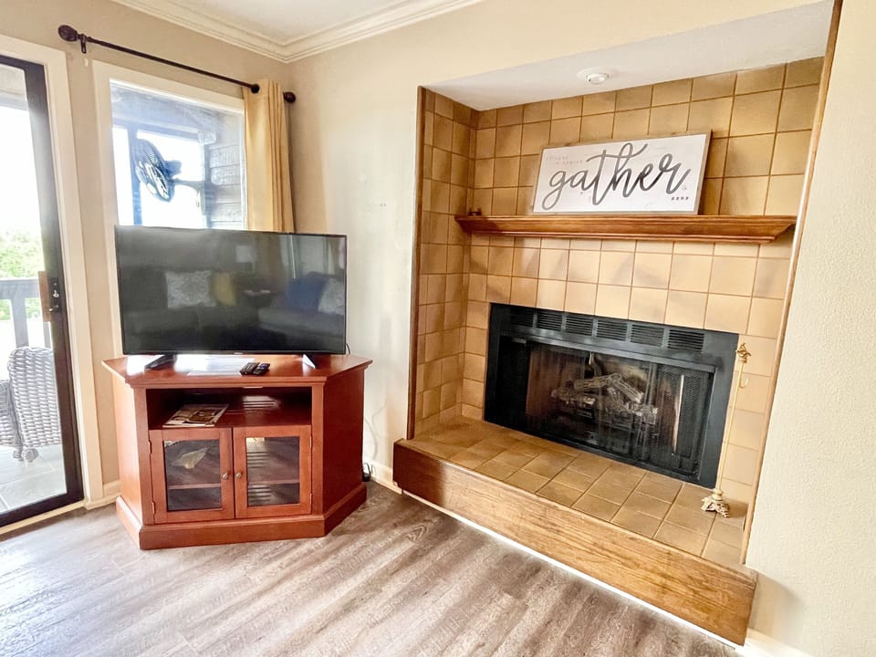 Living room: smart TV, fireplace, balcony access