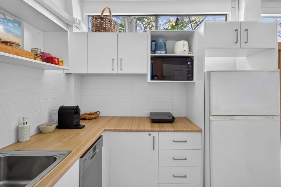 Fully equipped kitchen featuring a refrigerator, dishwasher, washing machine, and dryer, offering everything you need for a comfortable and convenient stay.