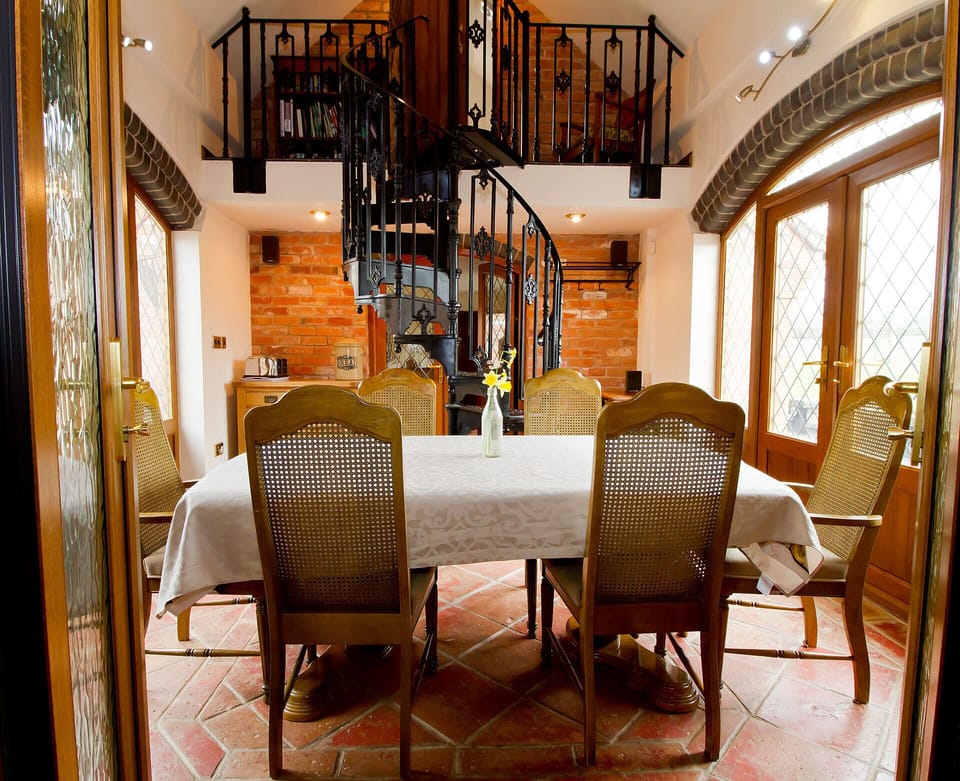 Coach House dining area spiral stair case leading to en-suite bedroom