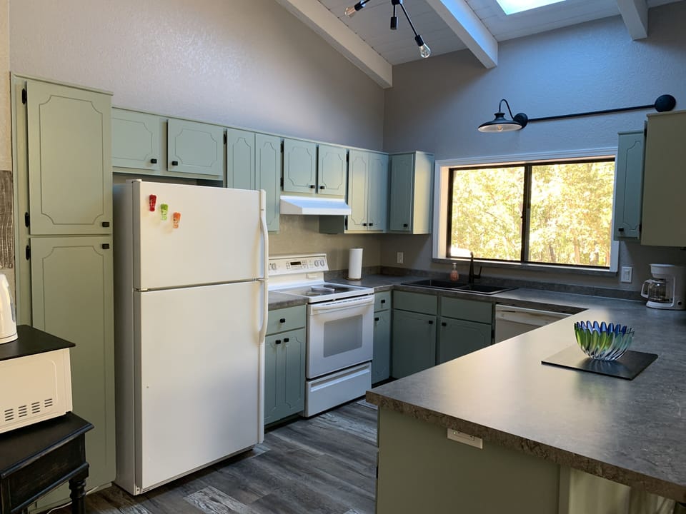 Kitchen with vaulted ceiling, skylight and large window
