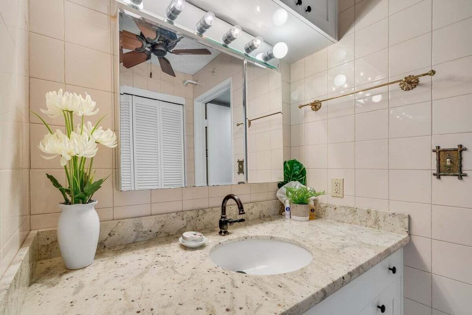 Granite vanity paired with fresh flowers and soft lighting, creating a spa‑like retreat.