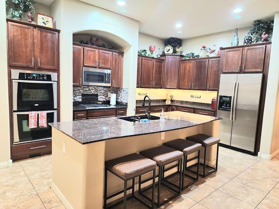 double ovens, microwave, gas range and dishwasher in fully stocked kitchen.