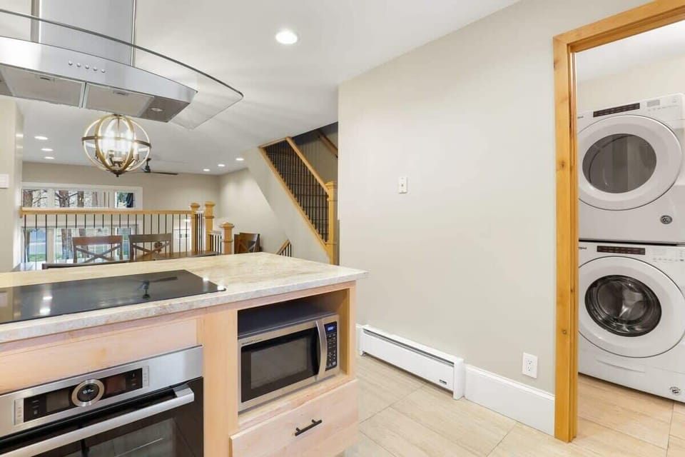 Mid-level area of the condo with a washer/dryer combo, kitchen, and dining area