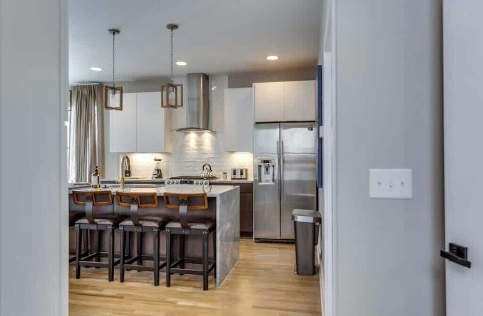 White-cabinet kitchen with sleek stainless steel double-door fridge