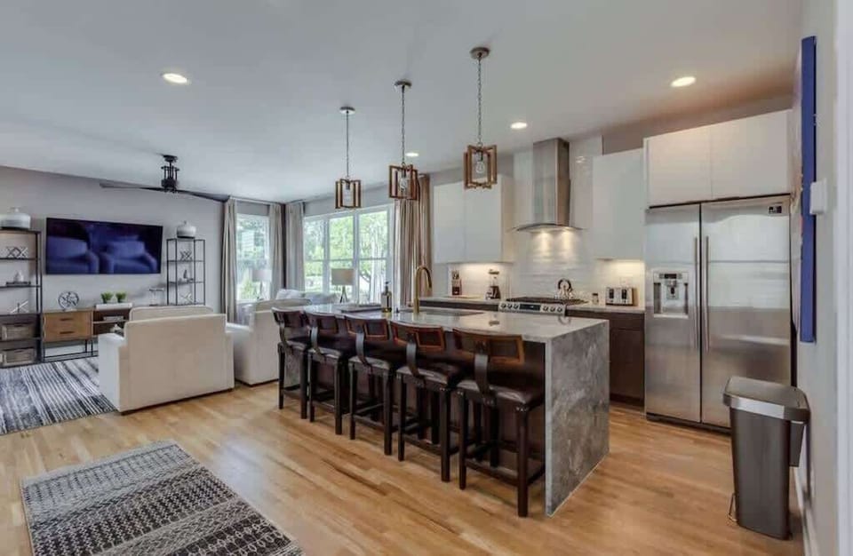 Modern kitchen and island counter with seating for five—your ideal coffee spot.