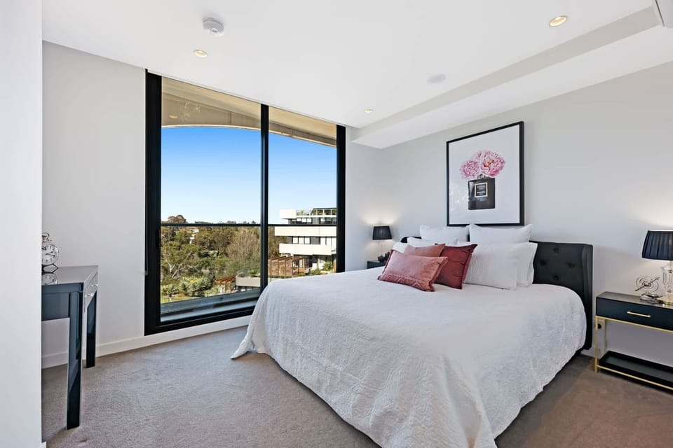 Queen-sized bed with large windows on the side.