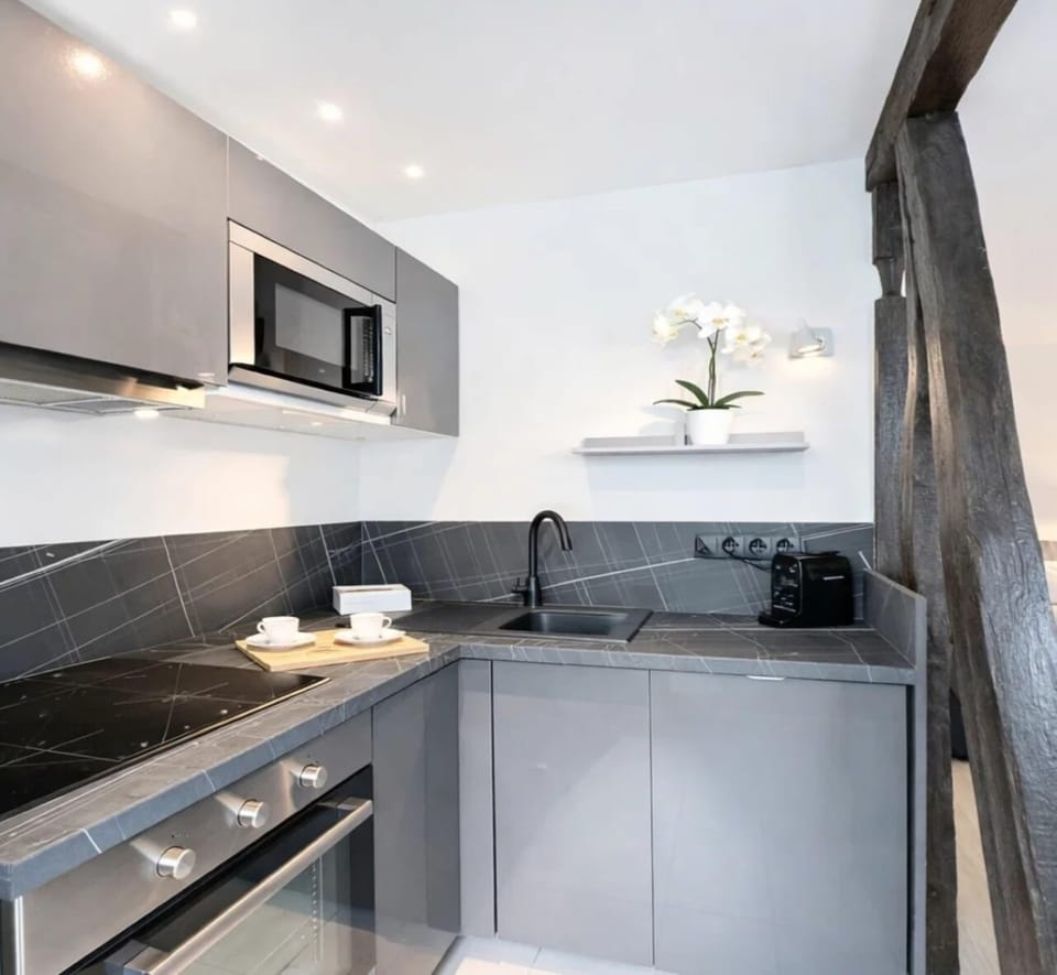 Convenient kitchen setup featuring essential appliances such as a refrigerator, stove, microwave, and Nespresso machine.