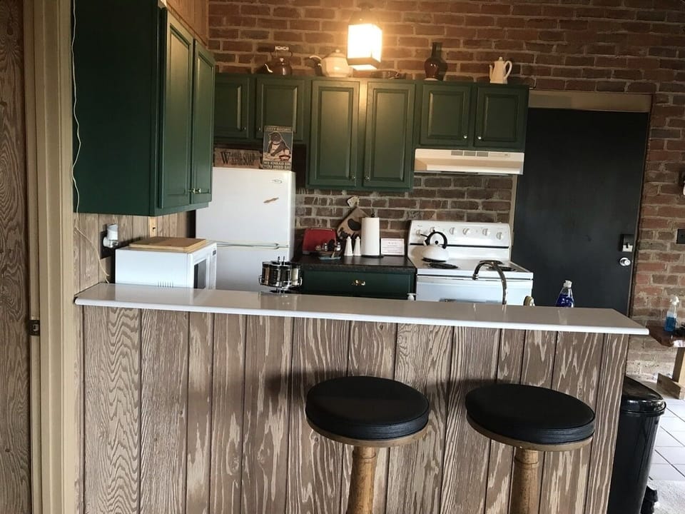 Fully equipped kitchen tastefully painted in hunter green with gold trim