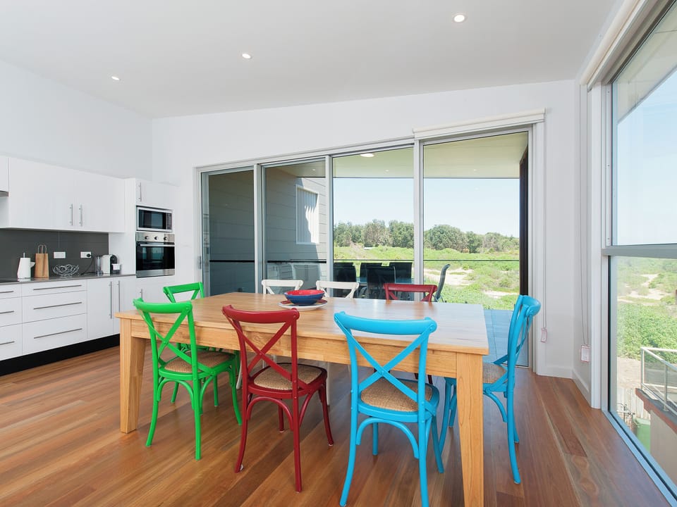 Bright dining space with colorful seating and scenic indoor-outdoor views