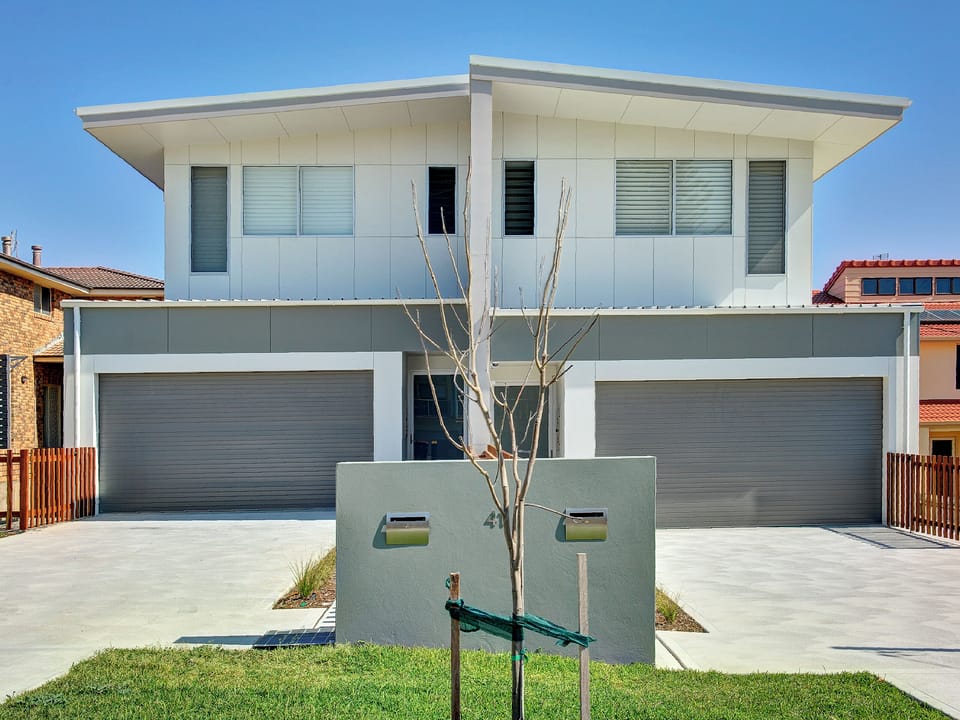 Modern duplex exterior with private garages and clean street appeal