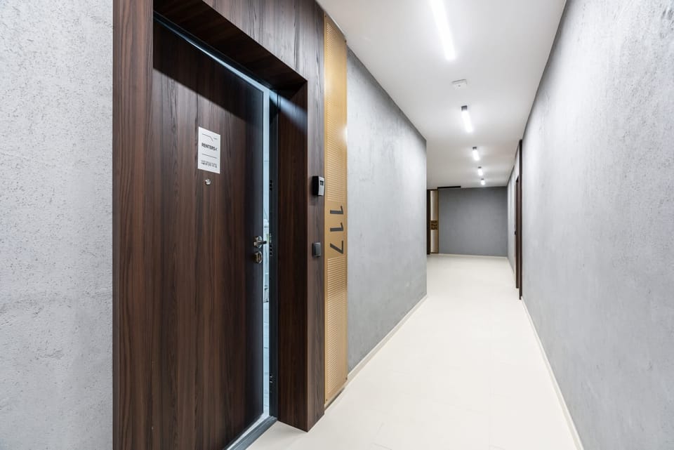 A clean, modern hallway with neutral tones and tiled flooring, creating a bright and inviting look.
