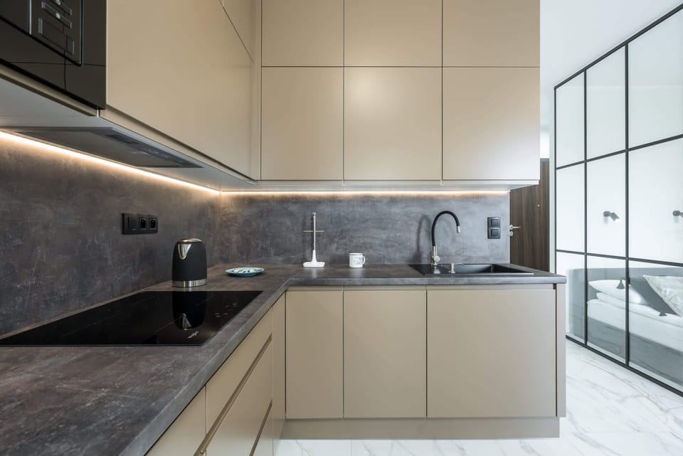 A bright, minimalist kitchen showcasing sleek cabinetry.
