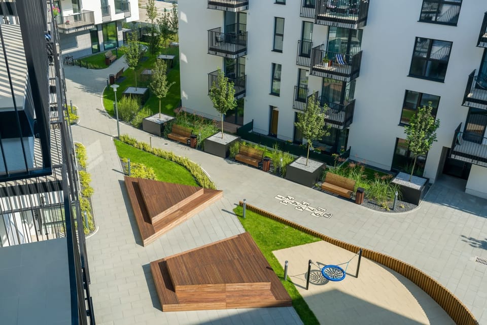 A beautifully landscaped courtyard with greenery, seating areas, and walking paths.
