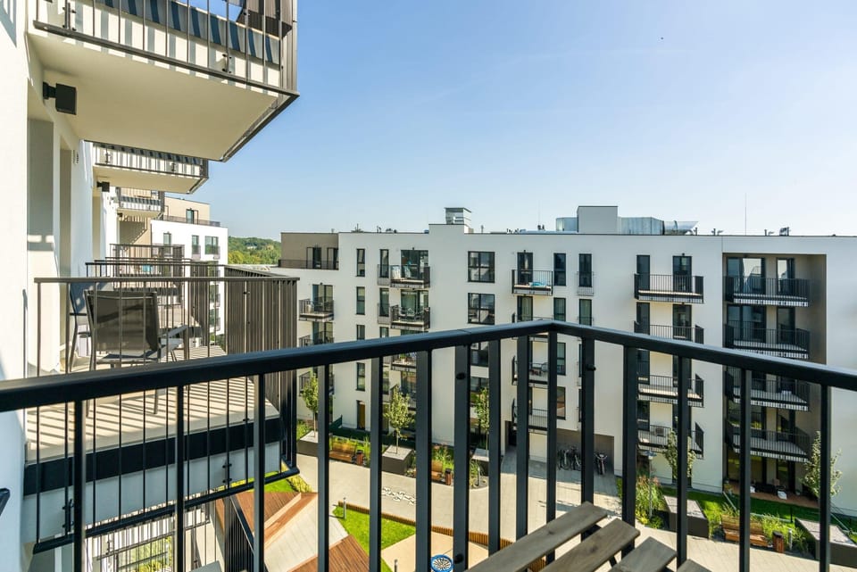 A balcony with black railings and a view of the surrounding buildings, perfect for relaxation.

