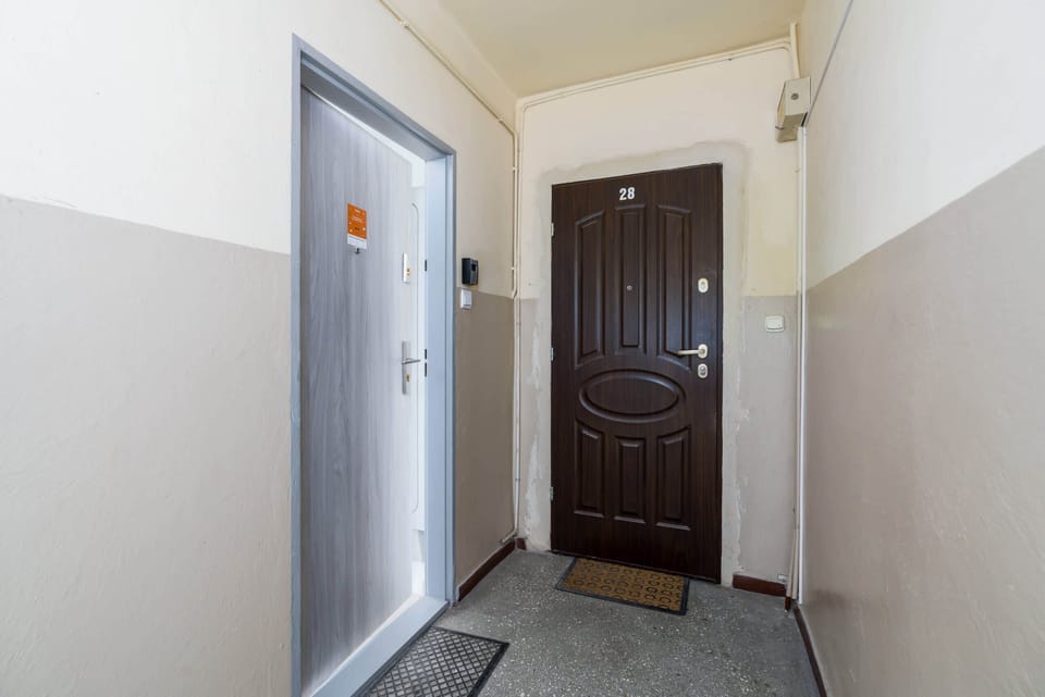 The entrance to the apartment, with a secure door and a clean, welcoming hallway.
