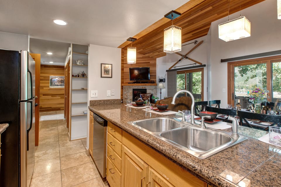 Fully Equipped Kitchen with stone countertops, stainless steel appliances, and bar seating for four