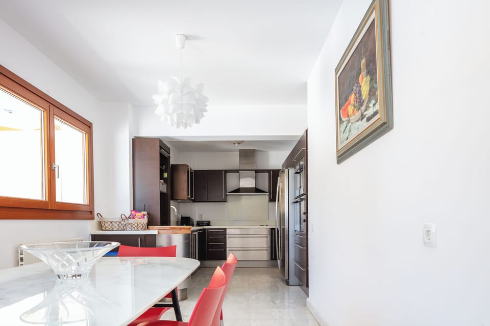A casual dining table in the kitchen area which seats 6 is next to the kitchen of second house.