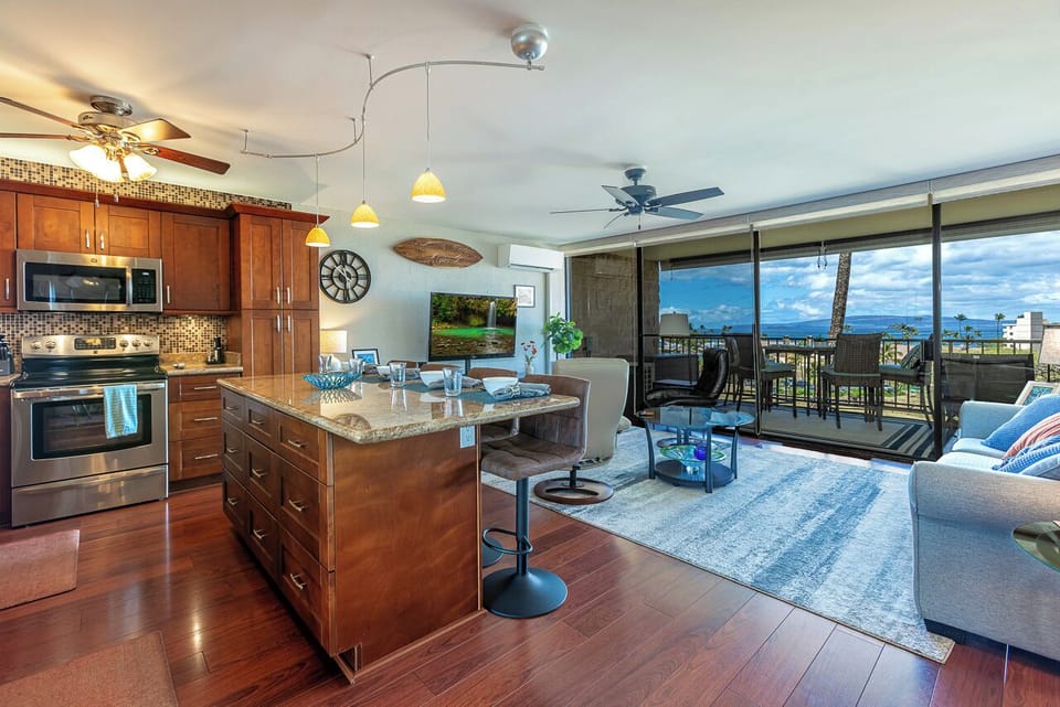 Enjoy the best of indoor-outdoor island living in this spacious open-concept great room, featuring a fully equipped kitchen, comfortable seating, and large sliding doors that open to the private lanai.