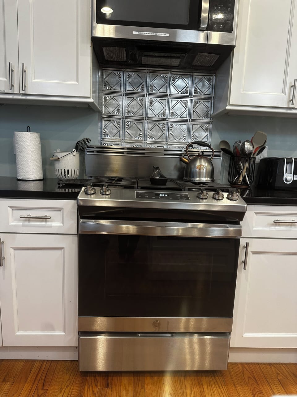 Large gas stove to cook on with 1 of 2 microwaves above
