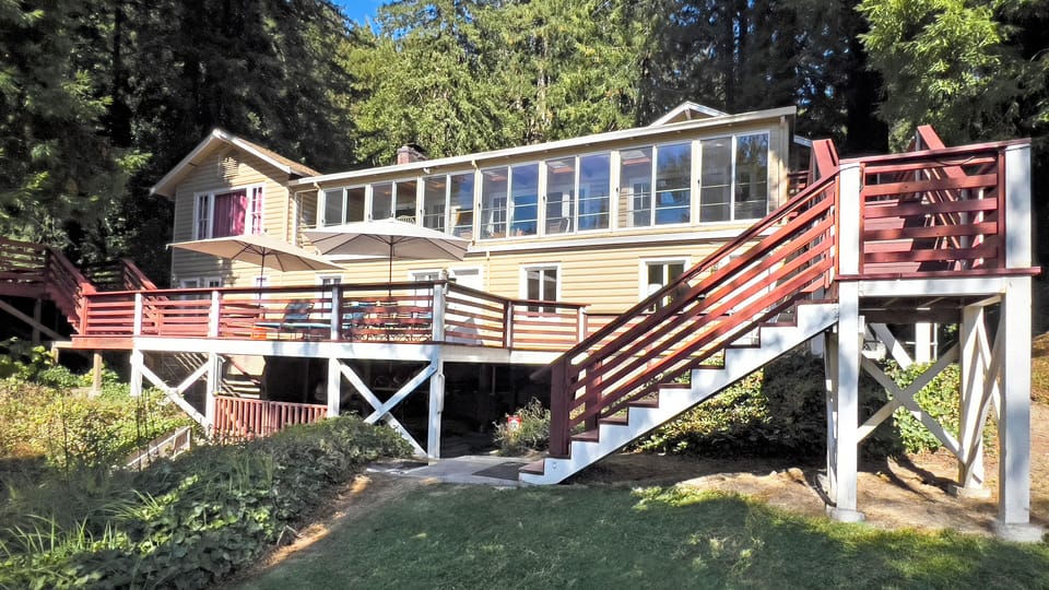 Deck space offering lounge area, dining area and riverfront views.