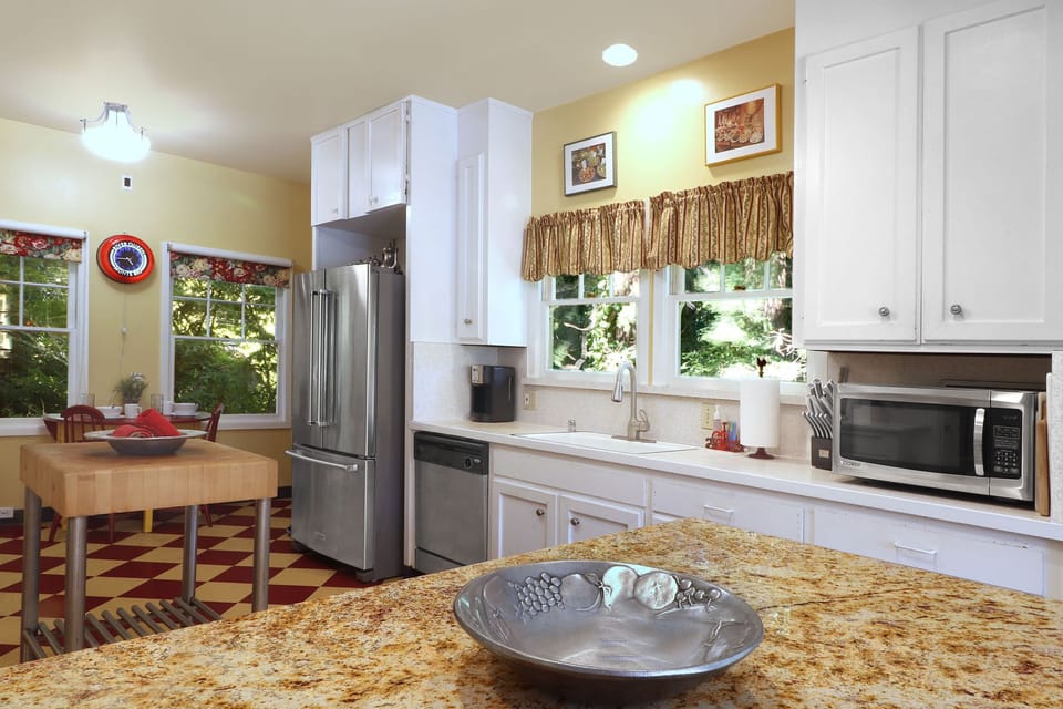 Upper level kitchen with stainless steel refrigerator, dishwasher, microwave.