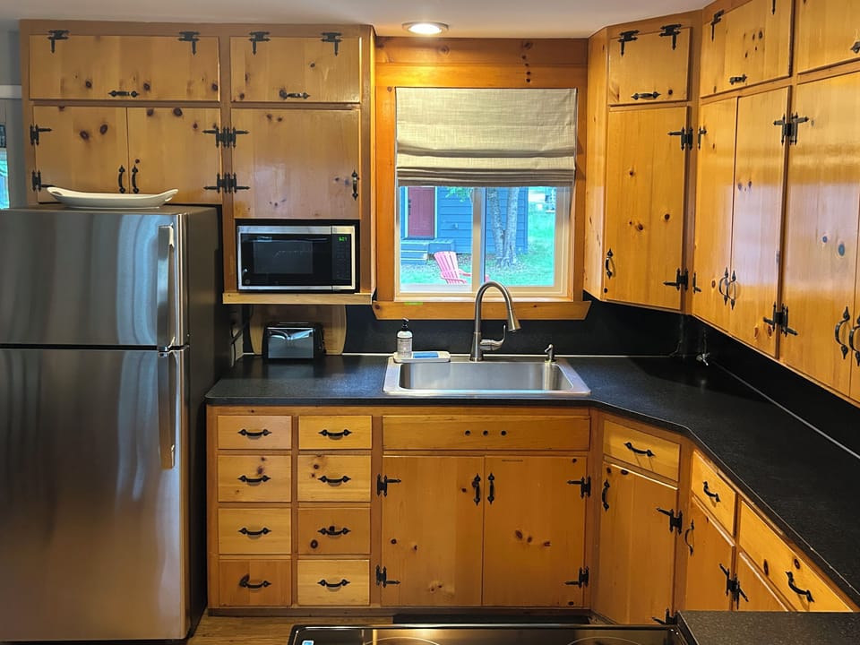Knotty pine kitchen stocked with new appliances to meet all your cooking needs. 
