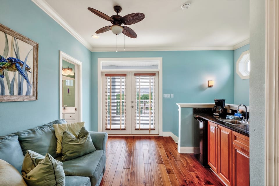 Cozy sitting area with a convenient kitchenette and French doors leading to a private outdoor space.