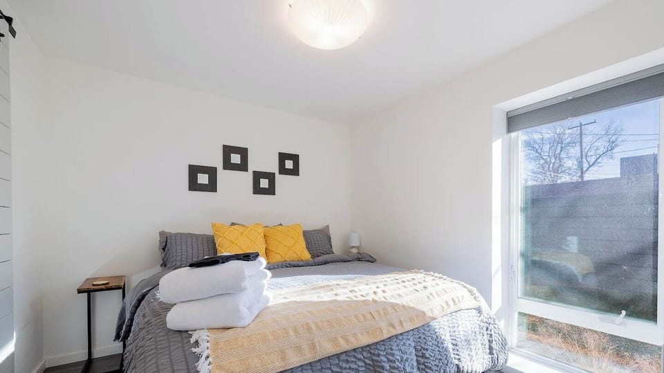 - Sink into a cozy comfortable bed layered with fresh linens and colorful accent pillows
- Start your day with gentle sunlight streaming through stylish windows
- Modern design meets comfort in this tranquil and inviting bedroom retreat