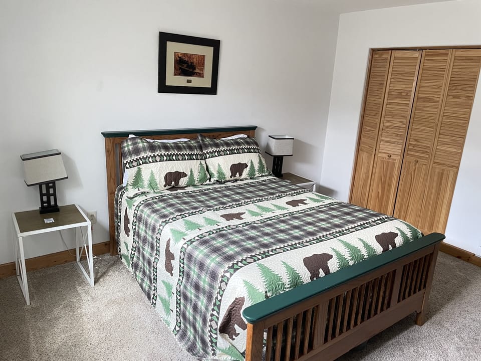 Downstairs bedroom with queen bed, dresser and closet.