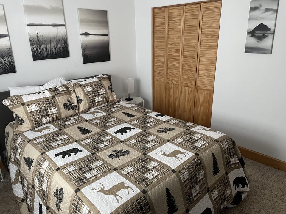 Upstairs bedroom with queen bed, dresser, and closet