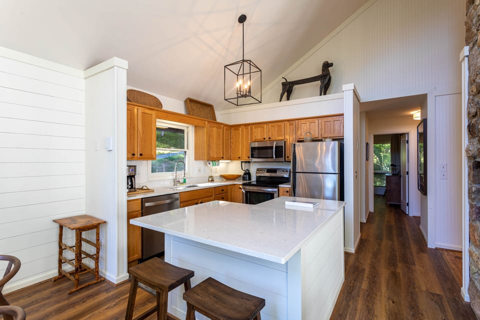 Open kitchen with L shaped island. 2 barstools available for quick meals