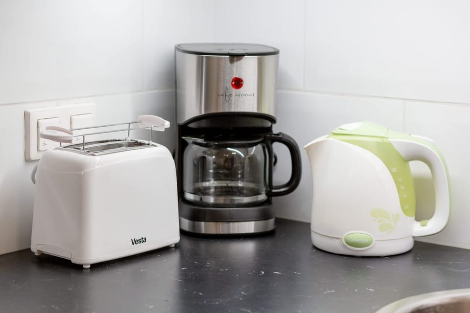 Kitchen setup with a coffee maker, toaster, and kettle.