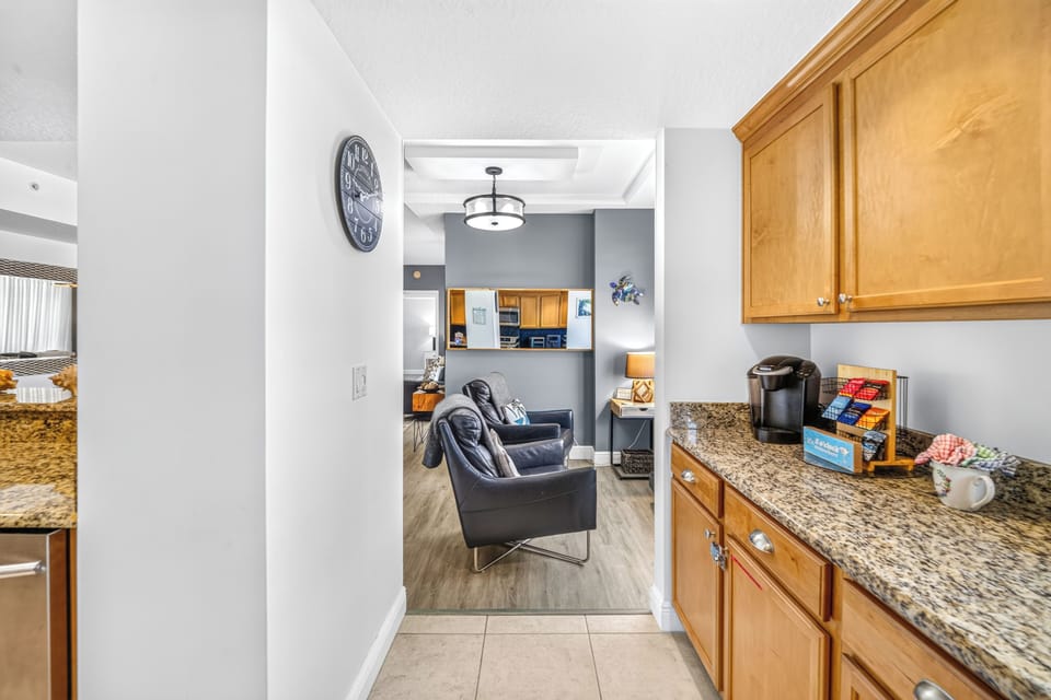 Your morning coffee awaits at the ready counter, stocked with K-cups and all the essentials before you settle into the cozy living area beyond.