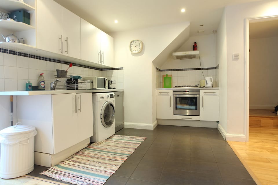 Kitchen with washer-dryer, dishwasher, oven, hob, microwave and coffee machine