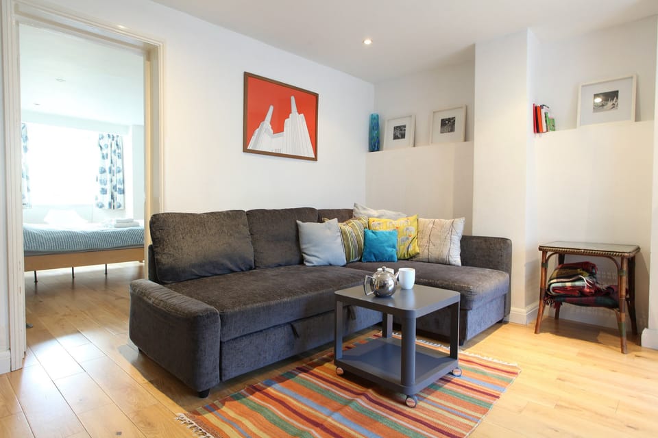 Living room with corner sofa bed and view into the bedroom