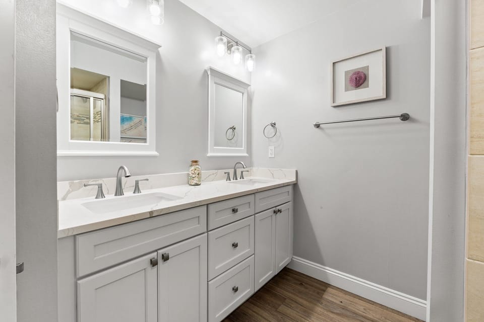 Elegant master bathroom with dual sinks, quartz countertops, modern fixtures, and bright mirrors for a spa-like retreat.