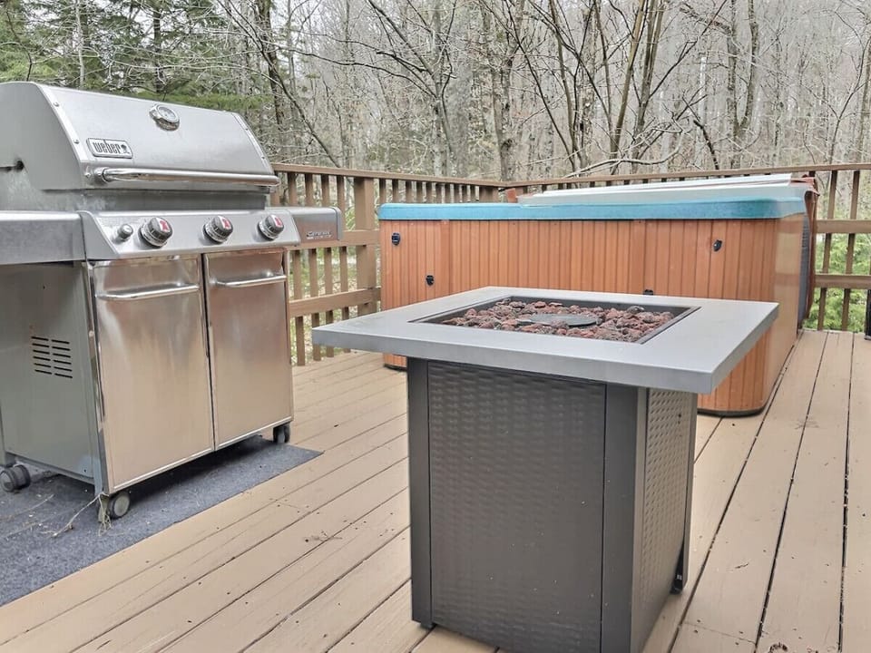 Enjoy outdoor living on our deck featuring a Weber grill, fire table for cozy evenings, and hot tub for ultimate relaxation.