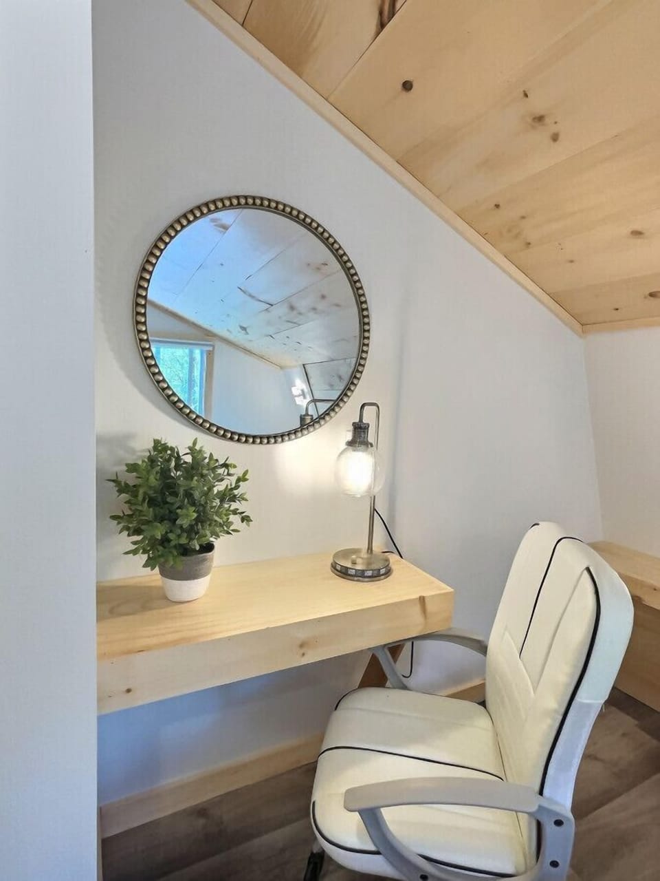 Office nook with a spacious layout and statement round mirror.