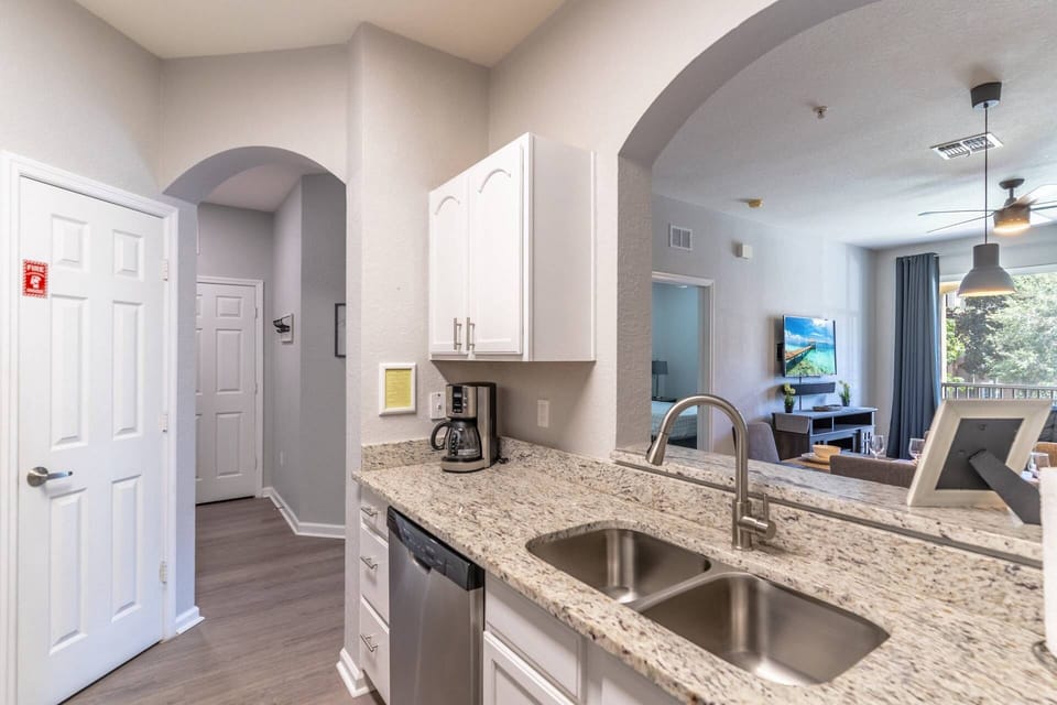 Modern Kitchen w/Stainless Steel Appliances and Granite Countertops overlooking the open floorplan dining and living room