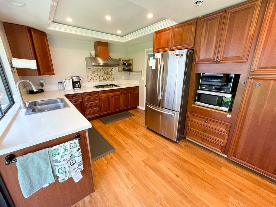 Full service kitchen, stocked with utensils, coffee makers, plates/bowls/cups.