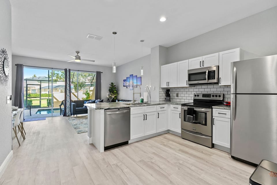 Well stocked, modern kitchen with stainless steel appliances & granite counters