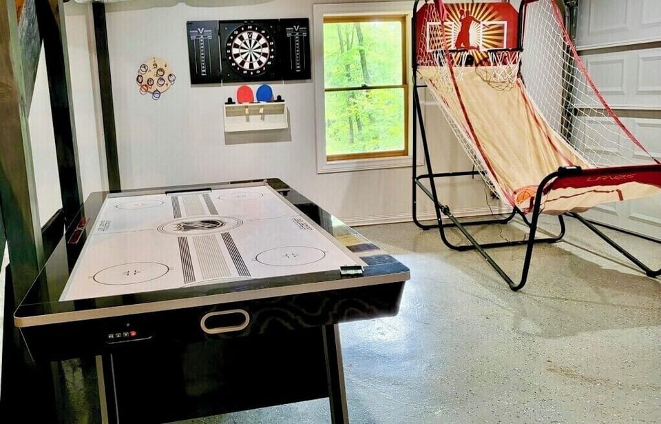 Game room with air hockey/ping pong table, dart board, 2 futons, great for kids!
