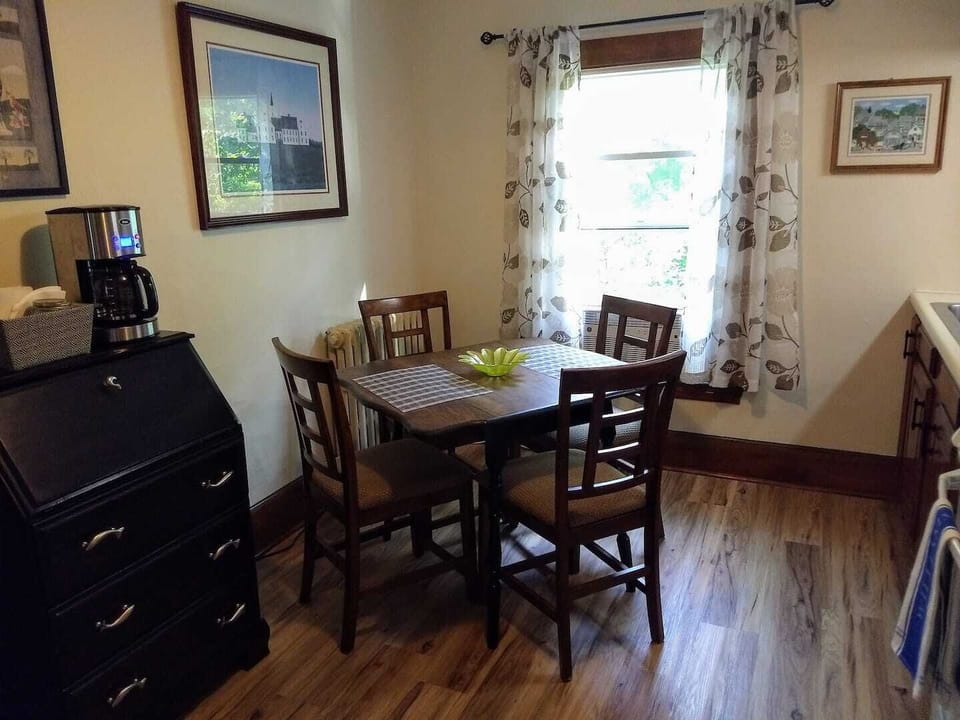 Dining table and chairs, window overlooks the backyard & river