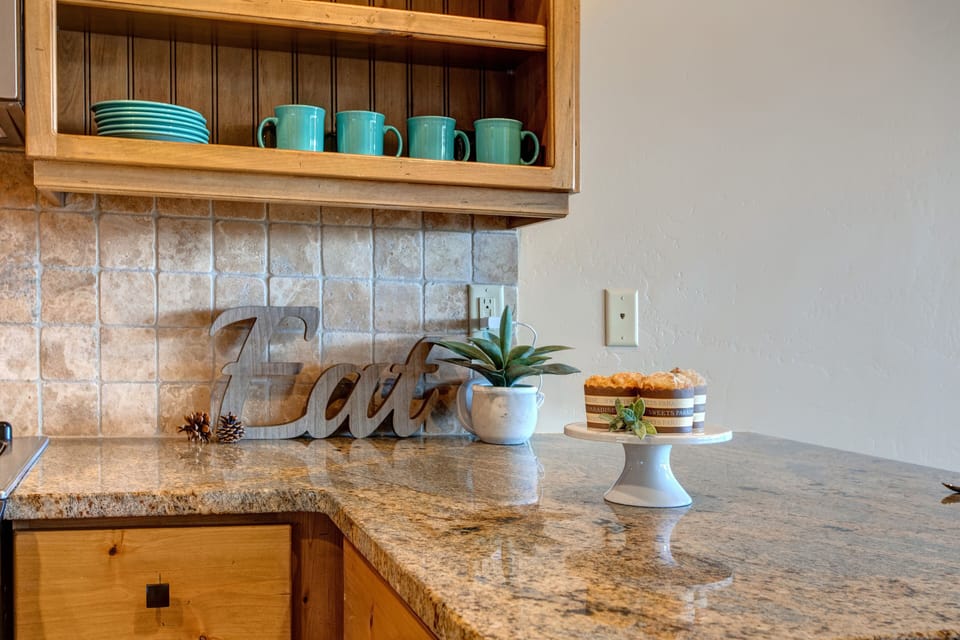 Fully Equipped Kitchen with stone countertops, stainless steel appliances, ice maker, and bar seating for three