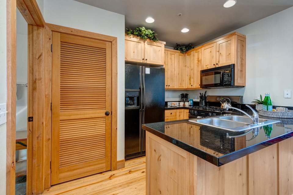 Fully Equipped Kitchen with gorgeous stone countertops, ice maker, private stacked laundry units, and shared full bath access